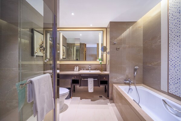 Un baño moderno con cabina de ducha de vidrio, una bañera grande y un tocador con espejo.