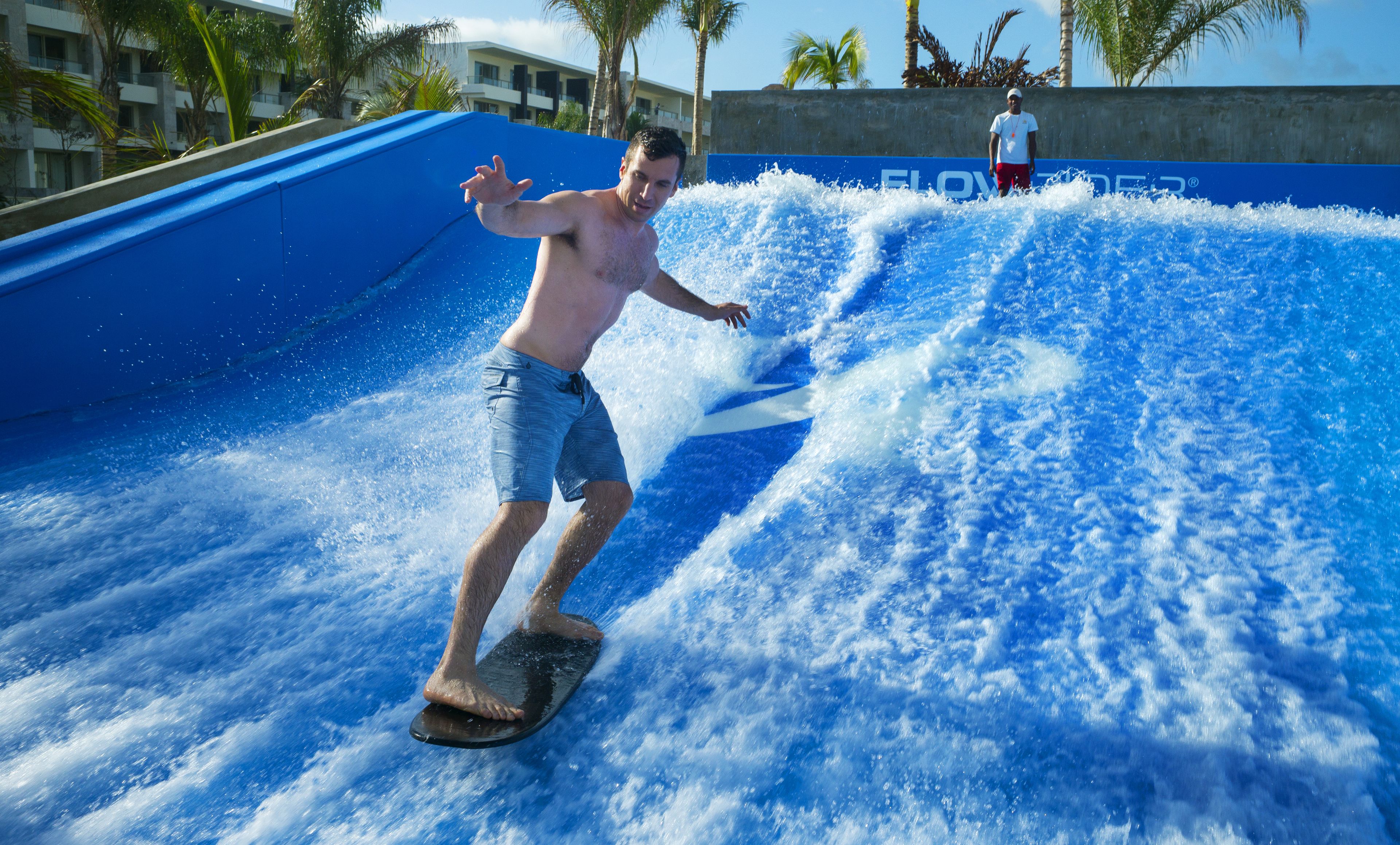 A man surfing on a wave in a water park.