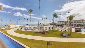 Un complexe hôtelier doté d’une piscine, de palmiers et offrant une vue sur la plage.