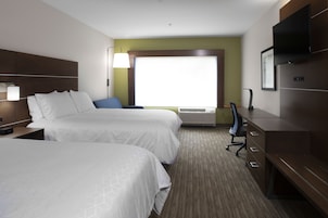 Habitación de hotel con dos camas, un escritorio, una silla, un televisor de pantalla plana y una ventana con vistas.