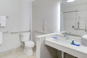 Uma casa de banho moderna com sanita, lavatório e chuveiro.