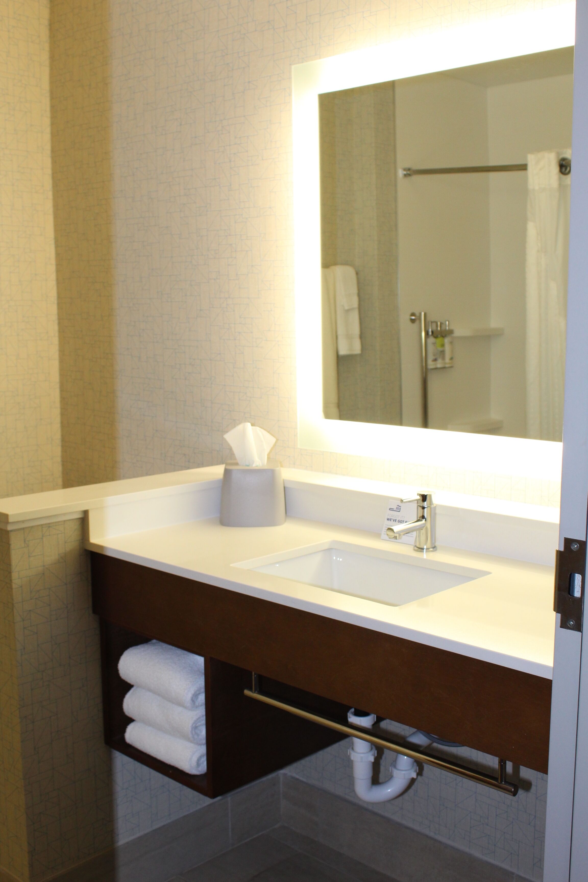 A bathroom with a white sink, a mirror, and a towel rack.
