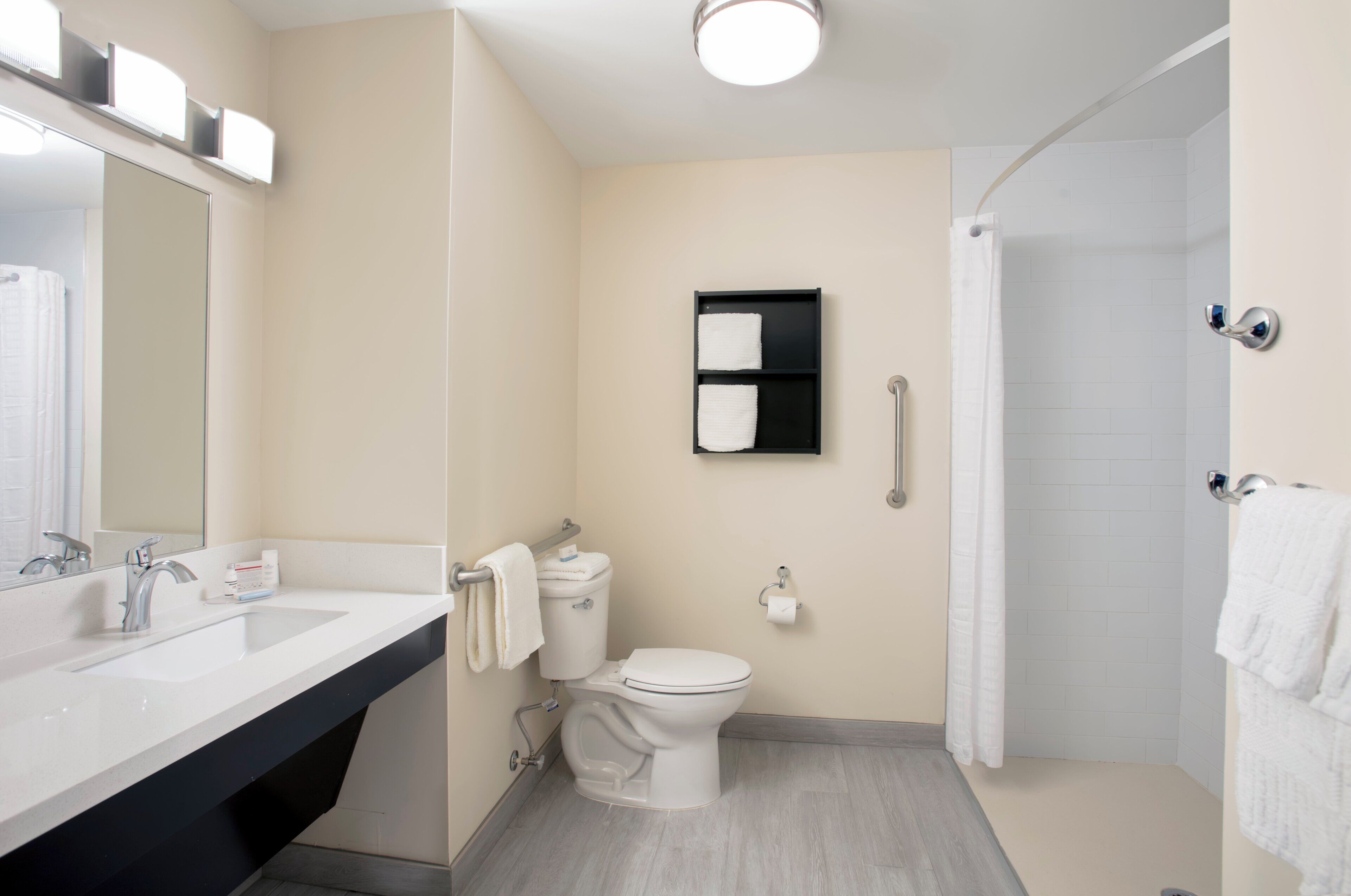 A modern bathroom with a white sink, toilet, and shower.