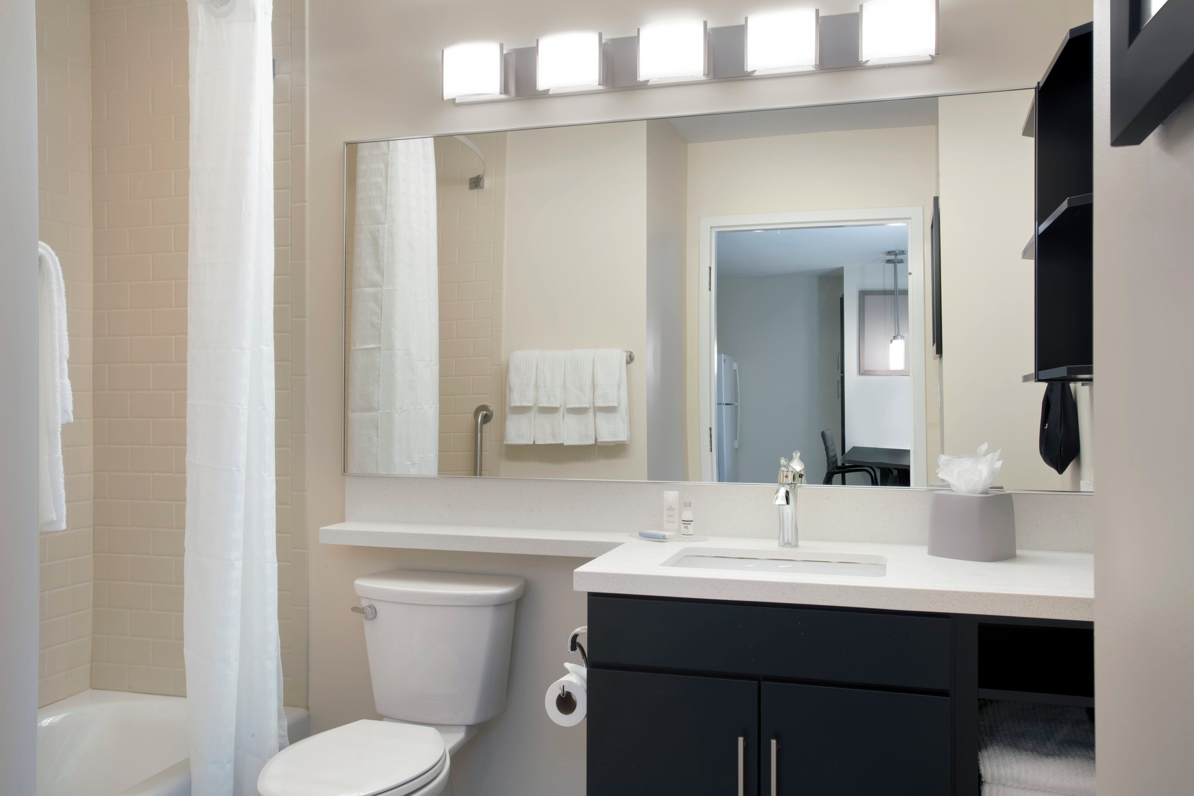 Ein modernes Badezimmer mit Toilette, Waschbecken und Spiegel.