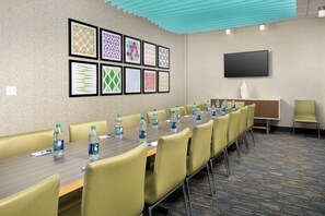 A conference room with a long table, chairs, water bottles, and framed artwork on the wall. - Holiday Inn Express and Suites North Brunswick by IHG (North Brunswick)