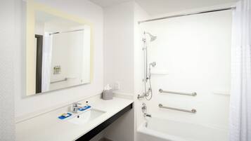 Un bagno moderno con lavandino, specchio e vasca da bagno bianchi.