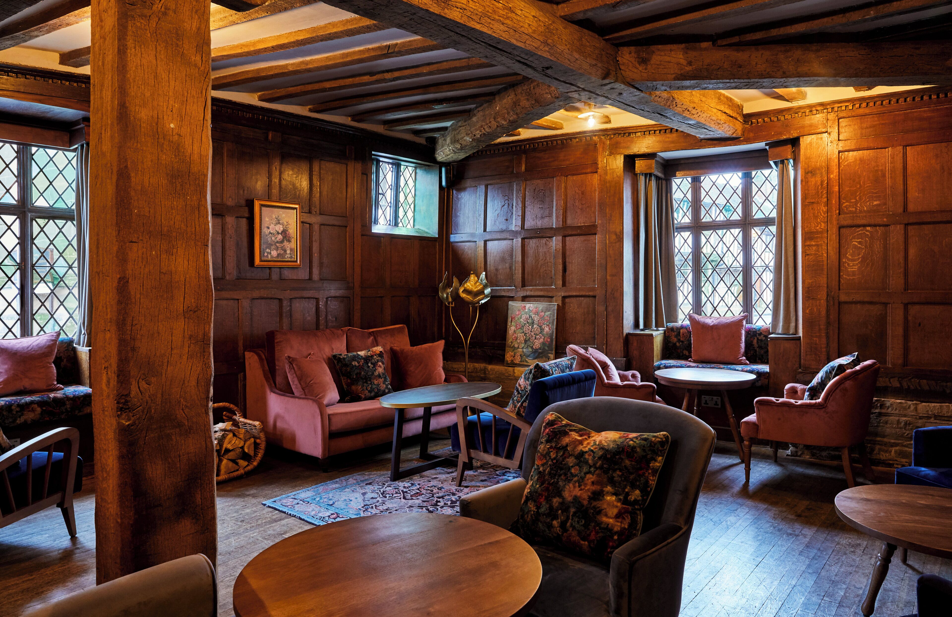A cozy room with wooden walls, a sofa, a table, and a chair.