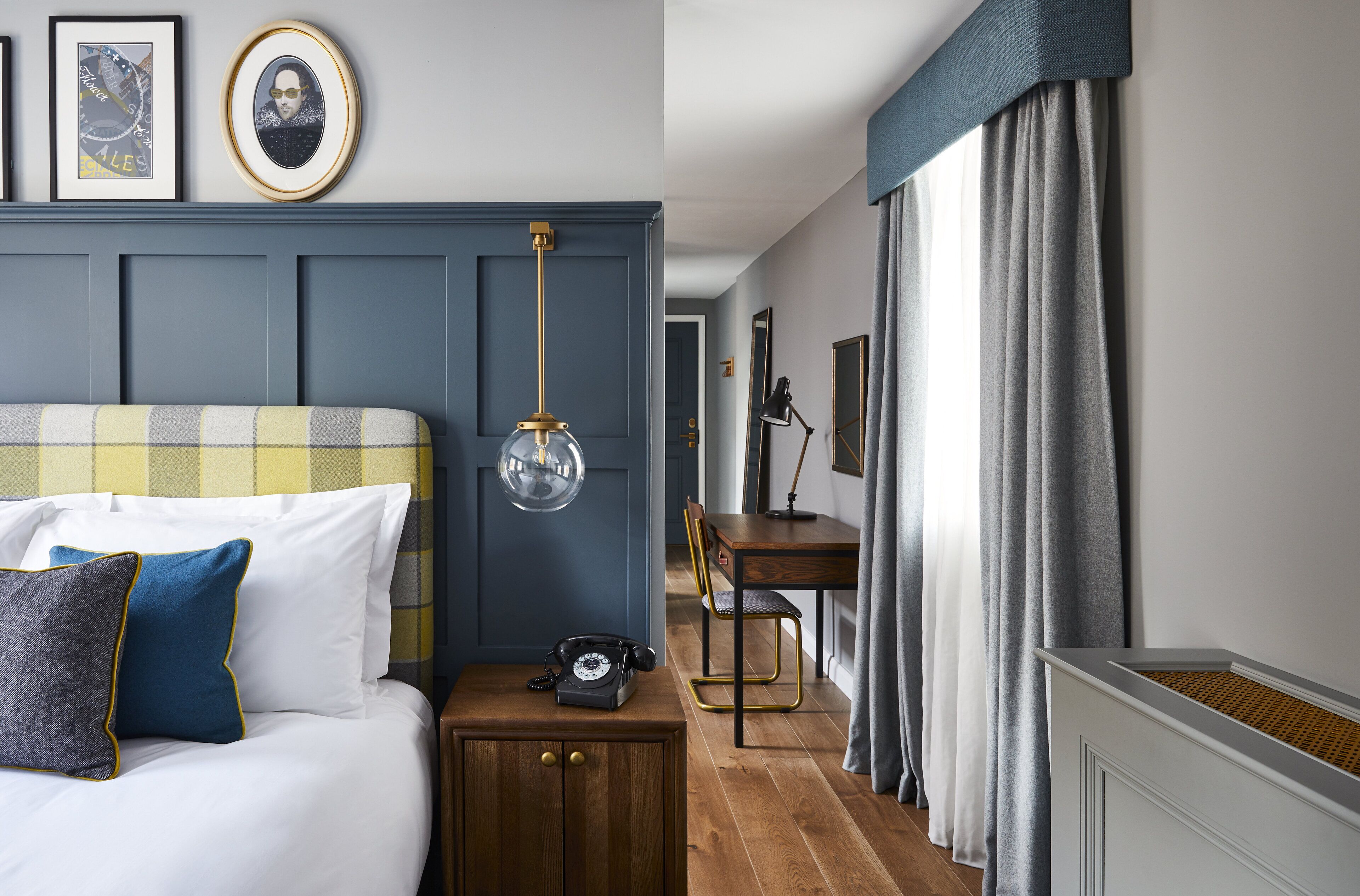 A bedroom with a bed, bedside table, and a desk with a chair.