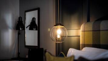 A room with a bed, a lamp, and a framed picture on the wall.