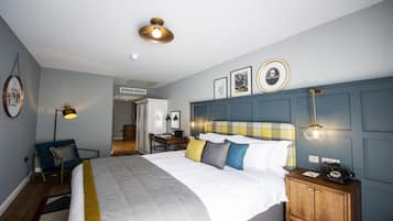 Una habitación de hotel con cama, mesita de noche, lámpara y armario.