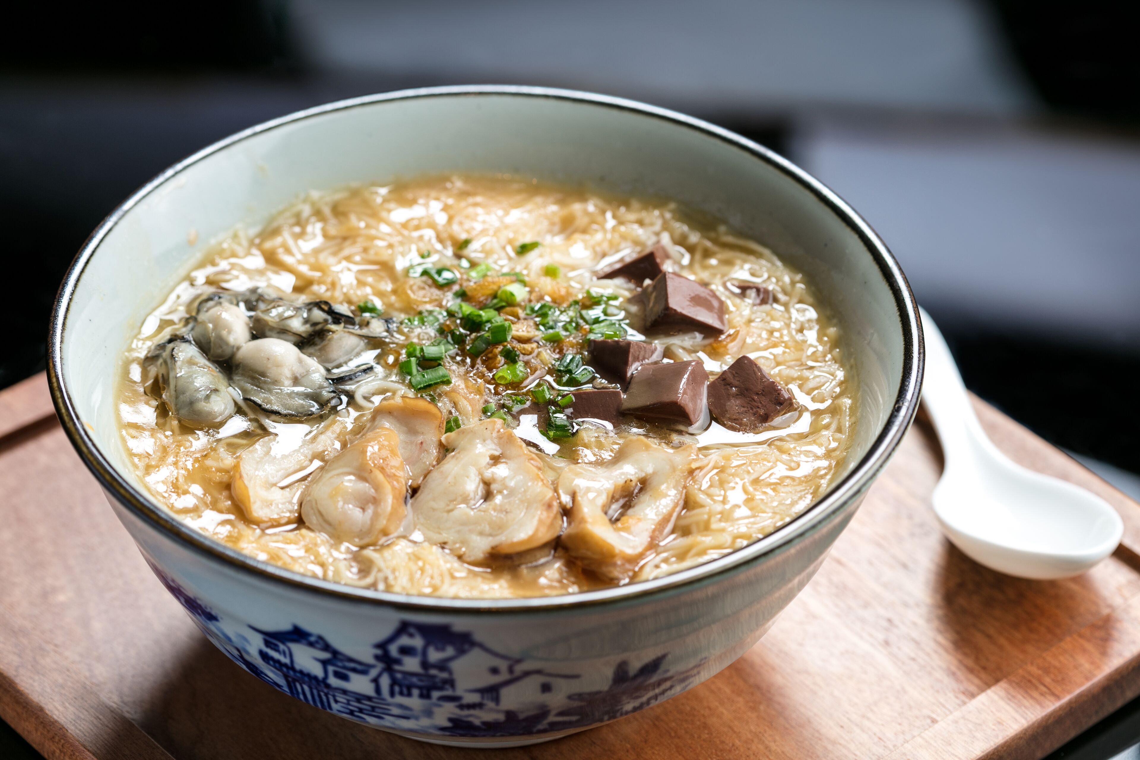 A bowl of ramen with noodles, meat, and mushrooms.