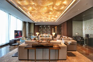 A modern living room with a large sofa set, a coffee table, and a television.