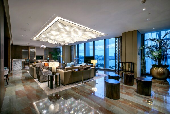 A modern hotel lobby with a large seating area, a central coffee table, and a large window offering a city view. - HUALUXE Xiamen Haicang Harbour View by IHG (Xiamen)