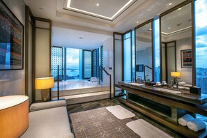 A modern bathroom with a large mirror, a bathtub, and a view of the city. - HUALUXE Xiamen Haicang Harbour View by IHG (Xiamen)