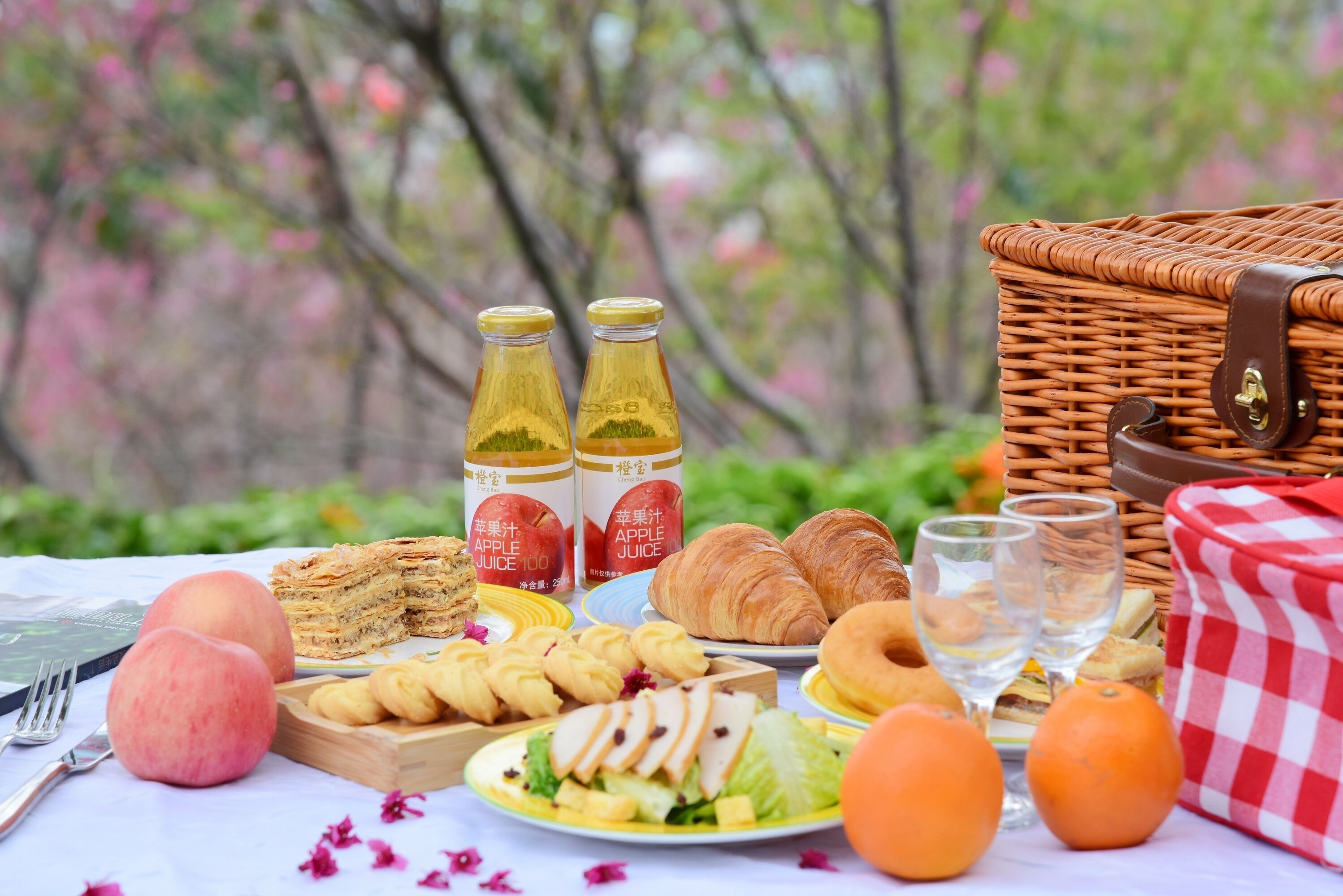 Un montaje para picnic con comida, botellas y una cesta.