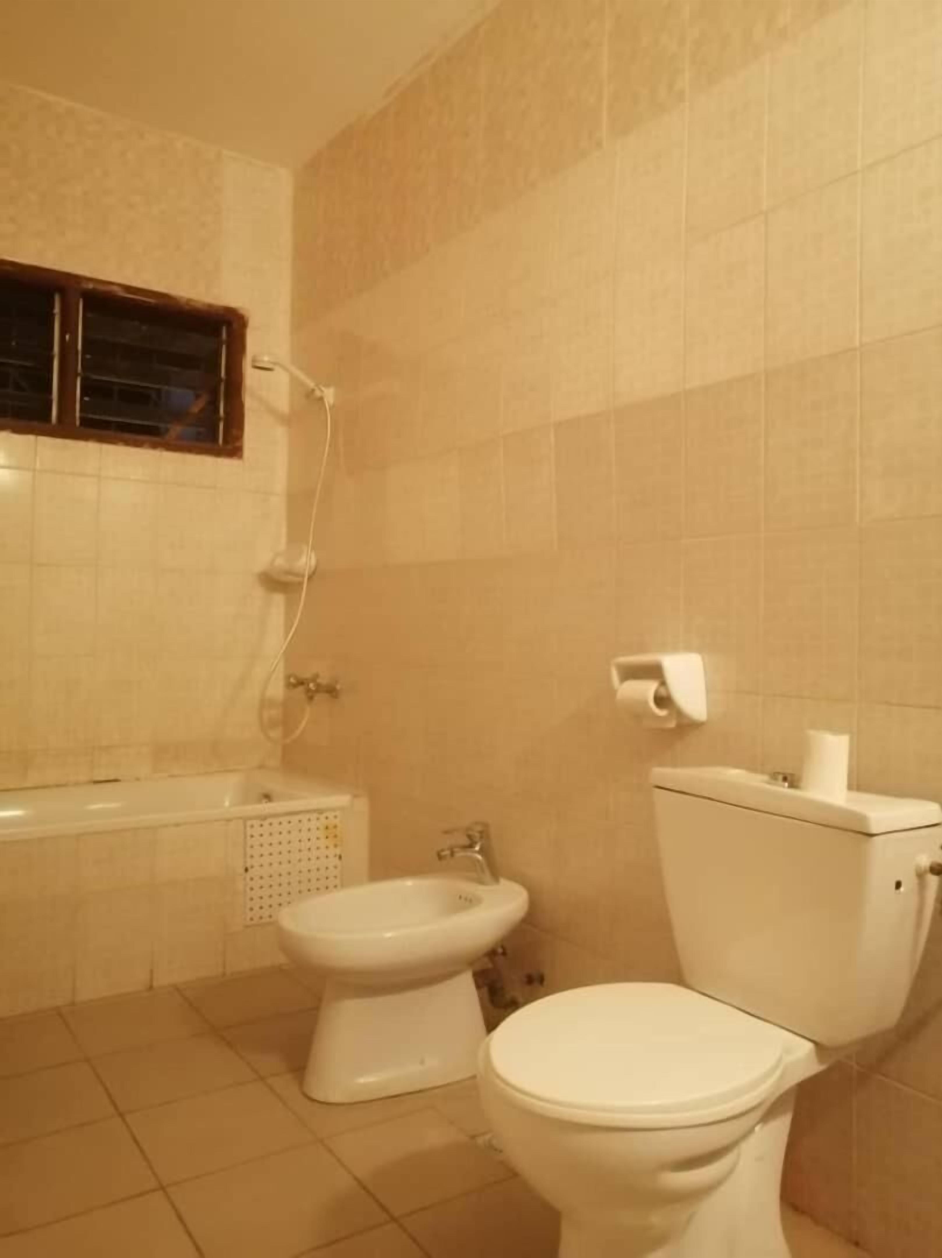 A bathroom with a bathtub, a toilet, and a bidet.