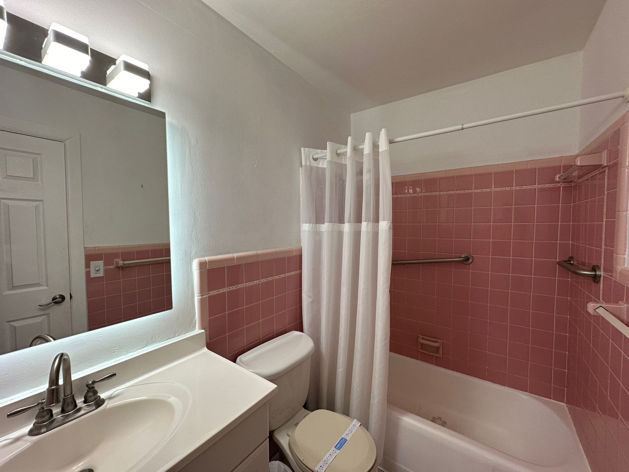 A bathroom with a white sink, a toilet, and a bathtub.
