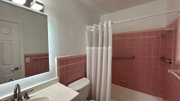 A bathroom with a white sink, a toilet, and a bathtub.