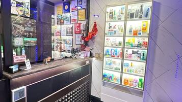 A reception area with a wooden counter, a glass display case with various products, and a wall with multiple signs and certificates.