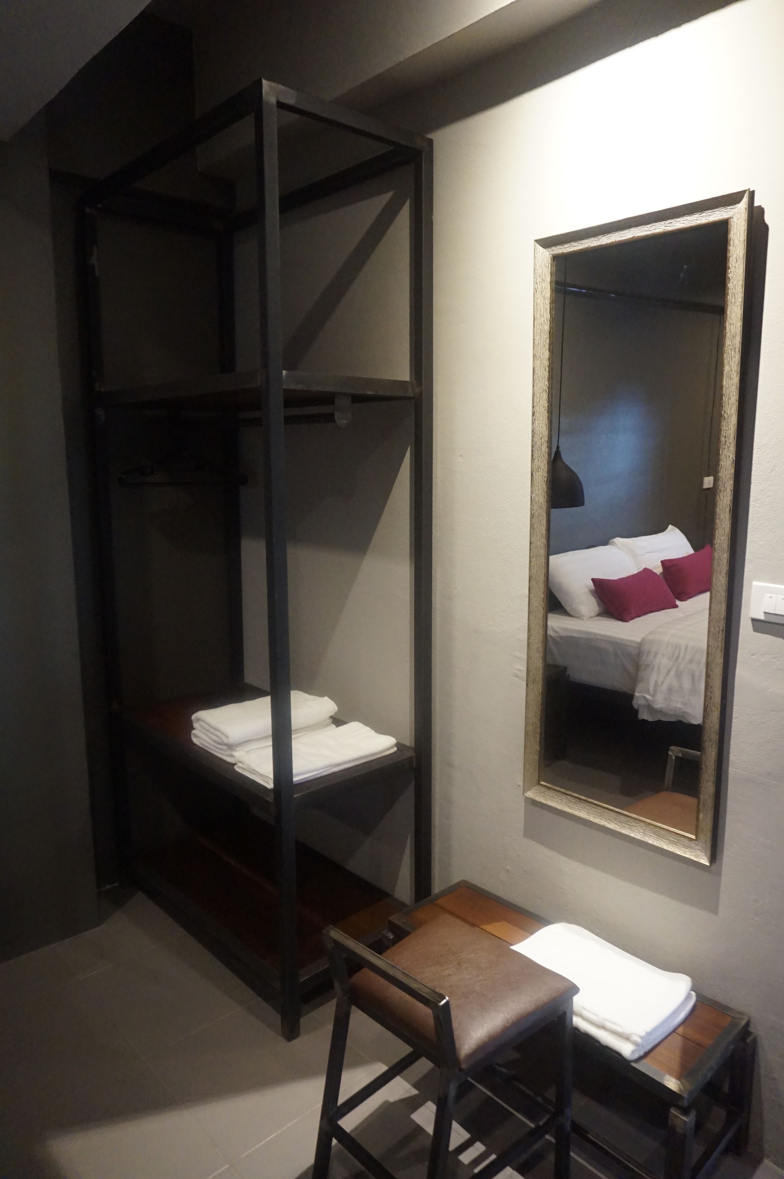A compact room with a bunk bed, a small table, and a mirror on the wall.