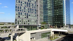 Un immeuble moderne de grande hauteur, doté d’une façade en verre et d’une série de fenêtres disposées en réseau.