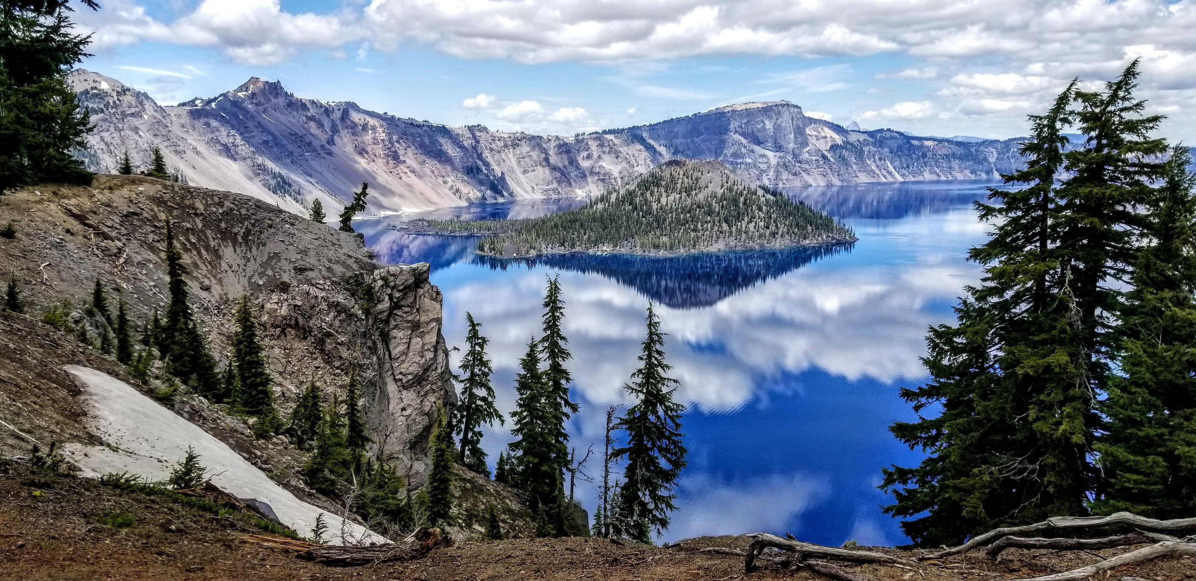 A mountainous landscape with a lake and forest.