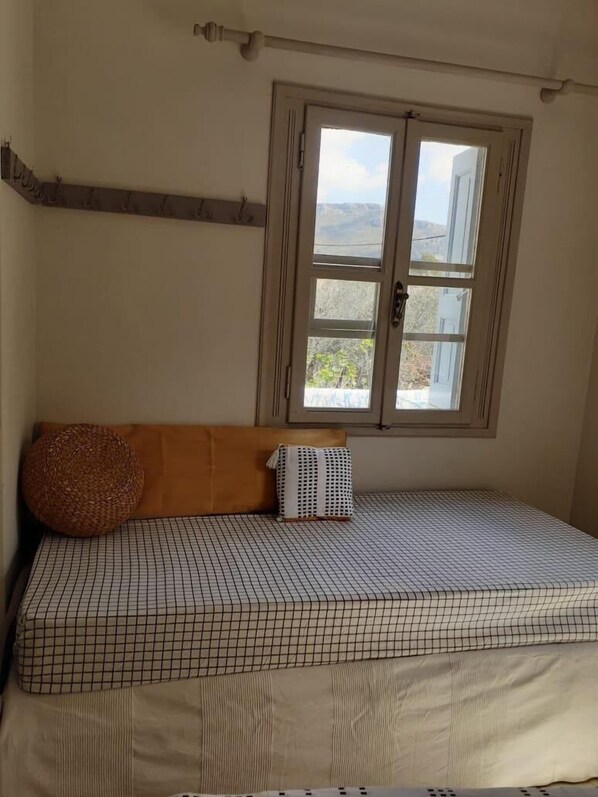 Une chambre à coucher avec un lit, une fenêtre et une poutre en bois au mur.