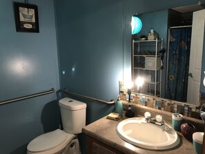 Een bad/douchecombinatie, een haardroger, handdoeken, zeep