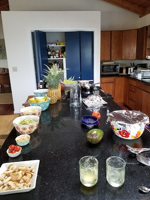 A kitchen counter with various food items and kitchen appliances. - Honomu Place - Resort Oasis (Honomu)