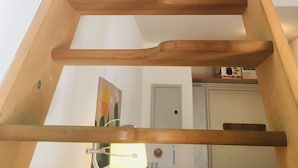 En trätrappa med ett räcke som leder upp till ett övre våningsplan.