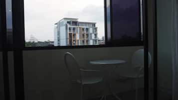 A room with a large window, two chairs, and a small table.