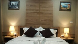 A hotel room with a large bed, two nightstands, two lamps, and two framed pictures on the walls. - Little Bear Guesthouse and Restaurant (Hat Yai)