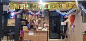 A restaurant with a wooden interior, a reception desk, and festive decorations.
