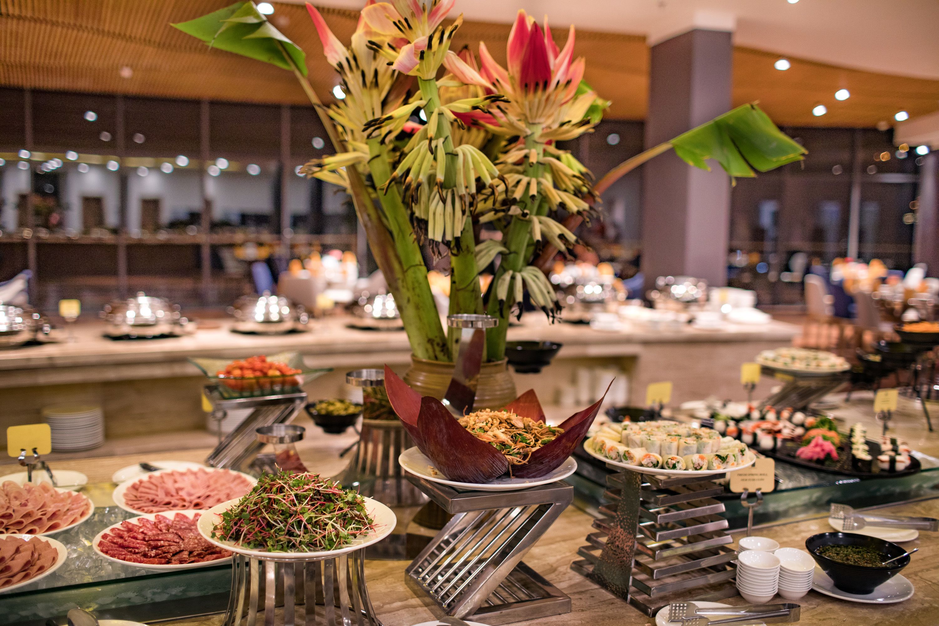 A buffet with various food items and a decorative centerpiece.