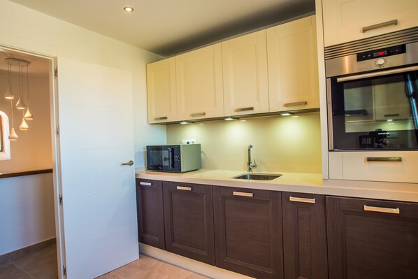 A modern kitchen with a microwave, toaster, and oven.