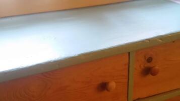 Une commode en bois avec quatre tiroirs et un plateau de couleur claire.