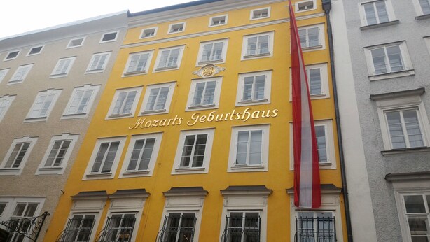 Ein Gebäude mit einer gelben Fassade und der Aufschrift "Mozarts Geburtshaus".