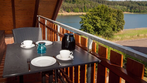 Ein Tisch für zwei Personen mit Blick auf See und Wald.