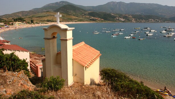 A coastal view with a church tower, beach, and boats. - APPIETTO, character house near Ajaccio in Corsica. "Between sea and maquis" (Appietto)