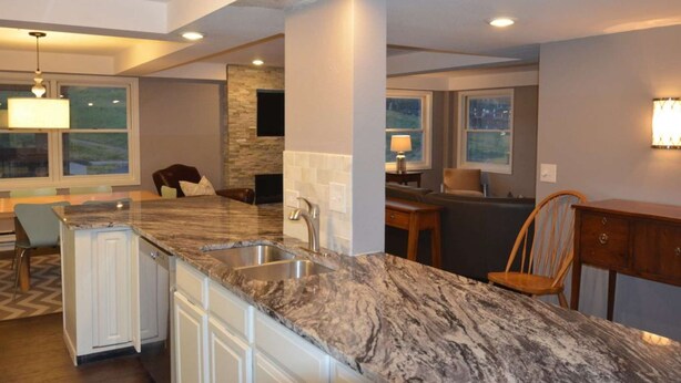 A modern kitchen with a marble countertop, a built-in sink, and a stone backsplash. - True Ski-in Ski-Out Luxury 3bd with Huge views from 5th floor end unit (Steamboat Springs)