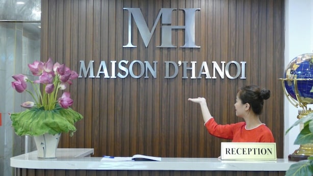 A reception desk with a sign reading "MAISON D'HANOI" and a "RECEPTION" sign. - Maison D'Hanoi Hotel (Hanoi)