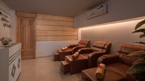 A spa room with leather massage chairs, a wooden door, and a wall-mounted air conditioner. - Maison D'Hanoi Hotel (Hanoi)