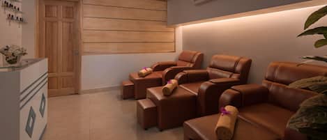 Ein Spa-Raum mit Ledermassagesesseln, einer Holztür und einer Wand-Klimaanlage.