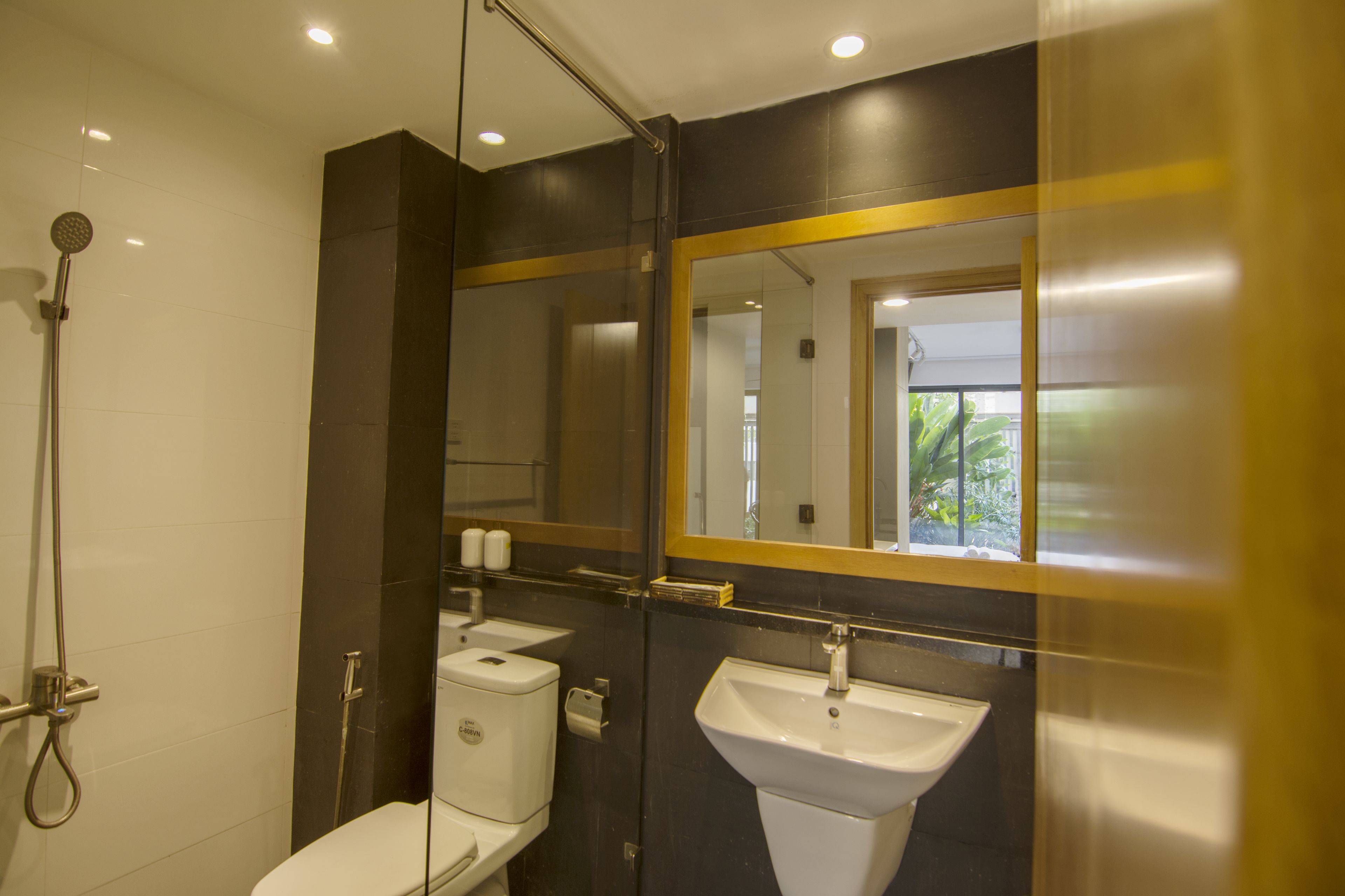 A modern bathroom with a glass shower enclosure, a white toilet, and a white sink.