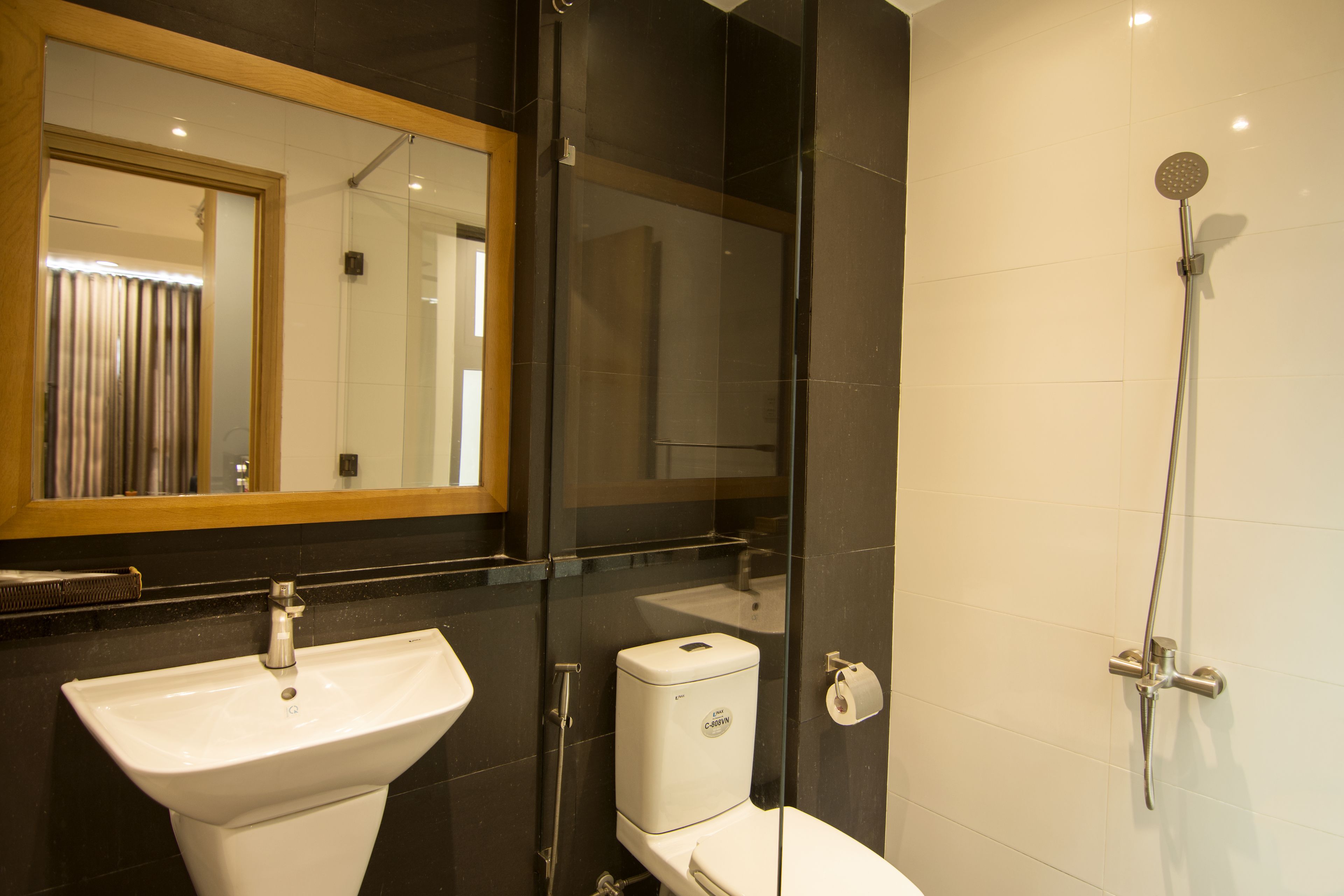 Une salle de bain moderne avec une douche à parois de verre, un lavabo blanc et des toilettes.