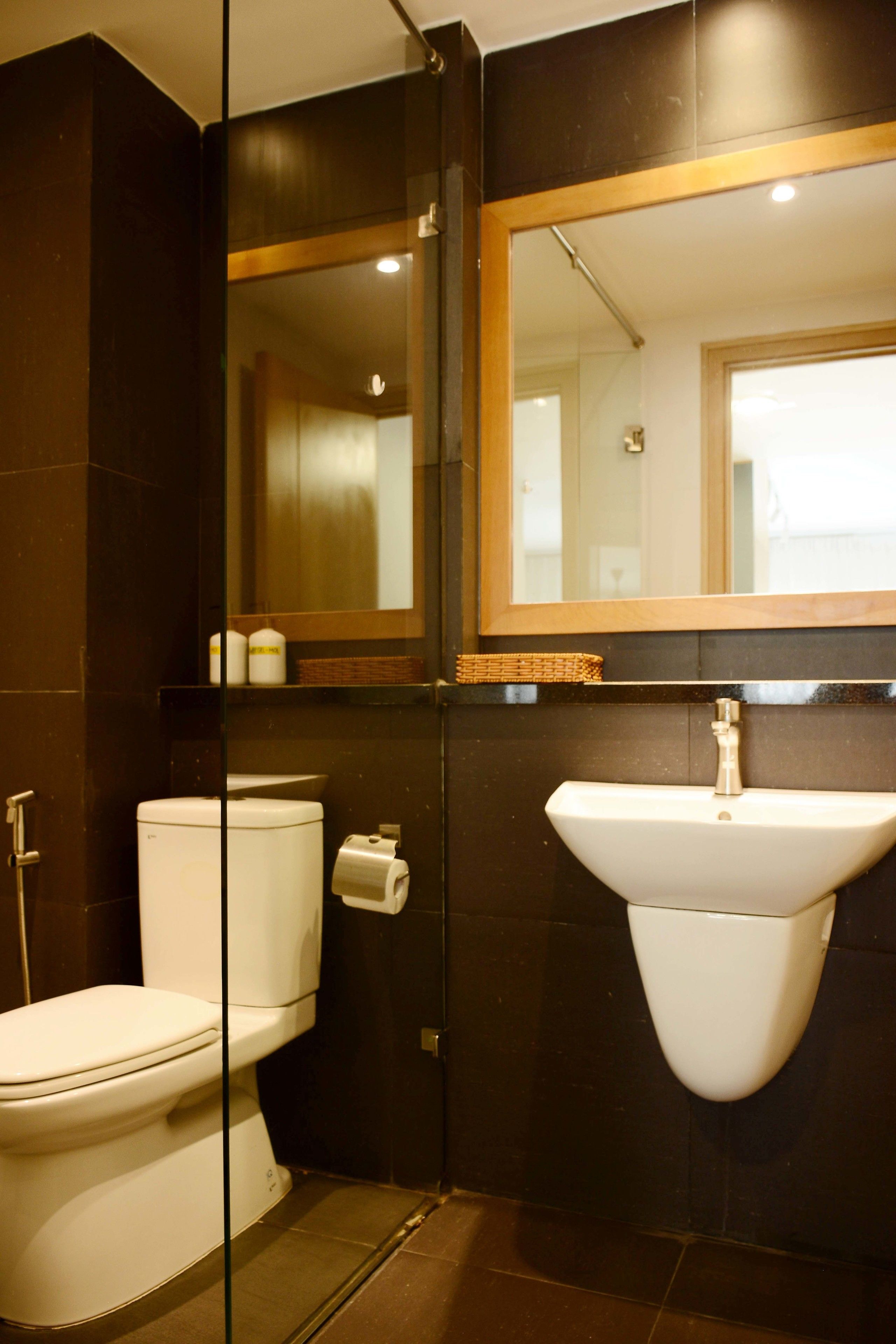 A bathroom with a toilet, a sink, and a mirror.