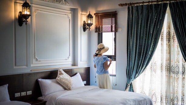 A hotel room with two beds, a large window with curtains, wall sconces, and a decorative ceiling. - Angelwings (Hualien City)