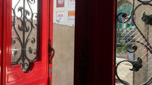 A red door with ornate metalwork and a window with decorative iron bars. - Angelwings (Hualien City)
