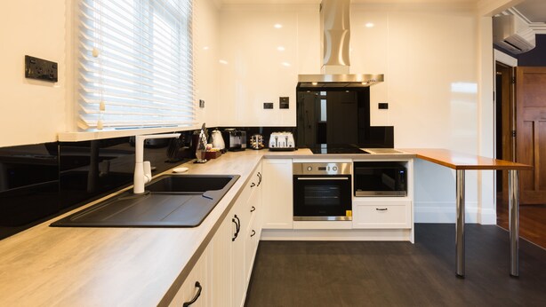 A modern kitchen with a built-in oven, microwave, and a stainless steel range hood.