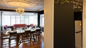 A dining area with a chandelier, a table set for four, and a wall with a memorial message.